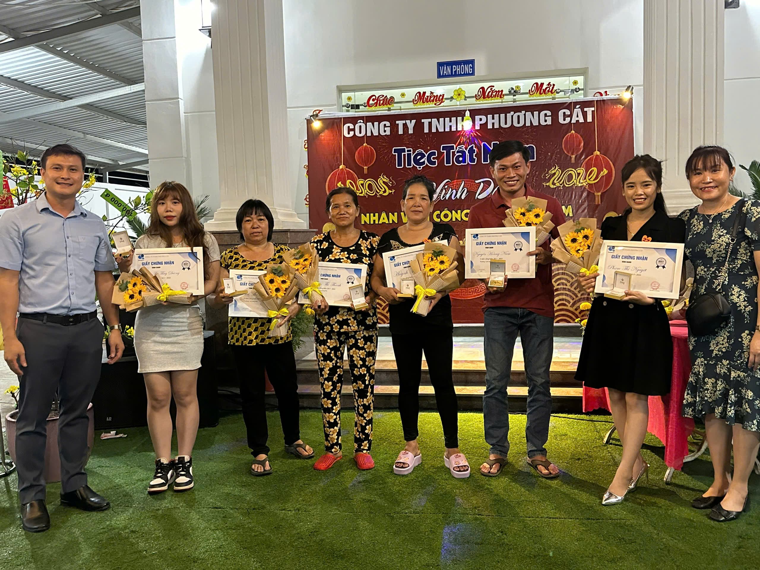 Phuong Cat team members receiving flowers and certificates at an internal event