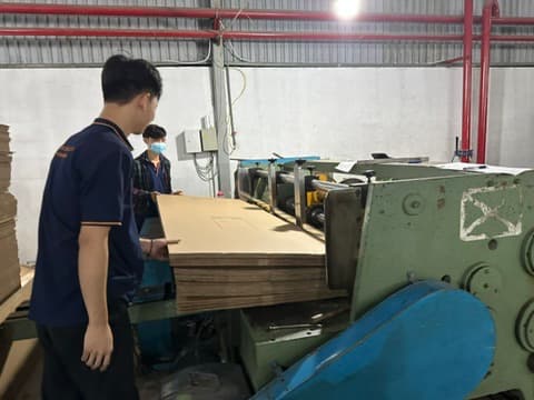 Staff operating the automatic carton slotting machine at the Phuong Cat factory