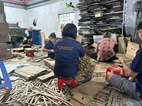 Staff removing excess board after carton die-cutting