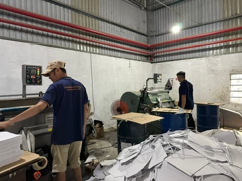 Staff operating the carton die-cutting machine at the Phuong Cat factory