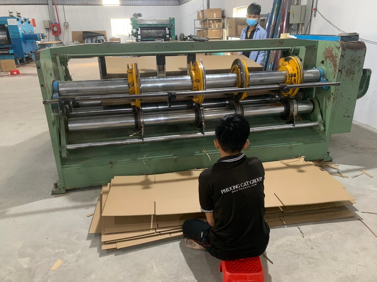 Staff operating the automatic creasing machine at the Phuong Cat factory