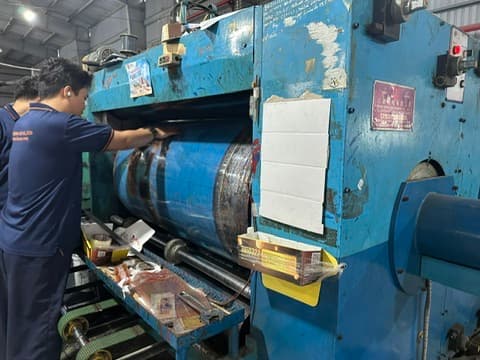 Staff operating the carton slitting machine at the Phuong Cat factory